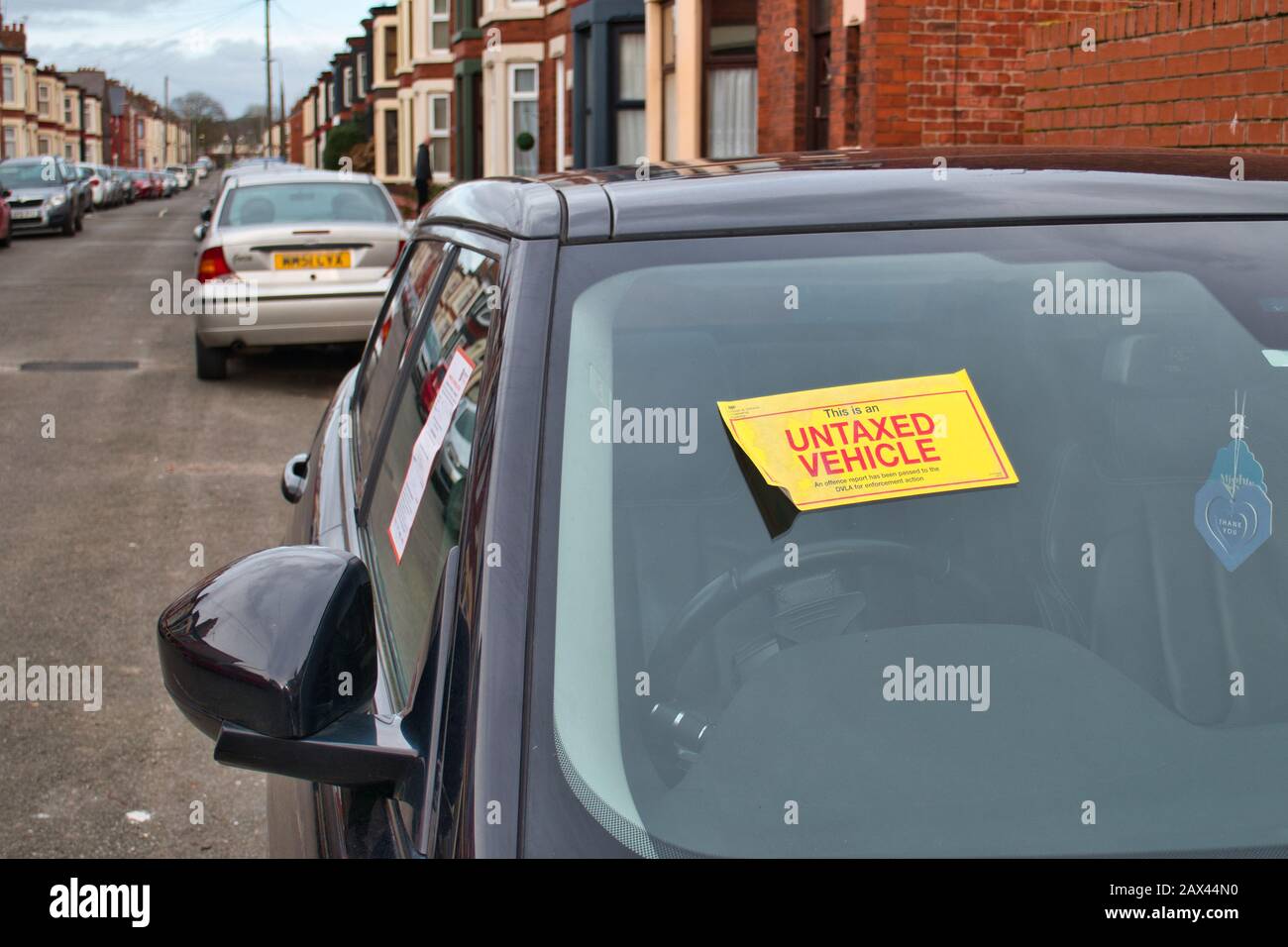 A notice is displayed on an untaxed vehicle advising that a report has been passed to the DVLA for enforcement action Stock Photo