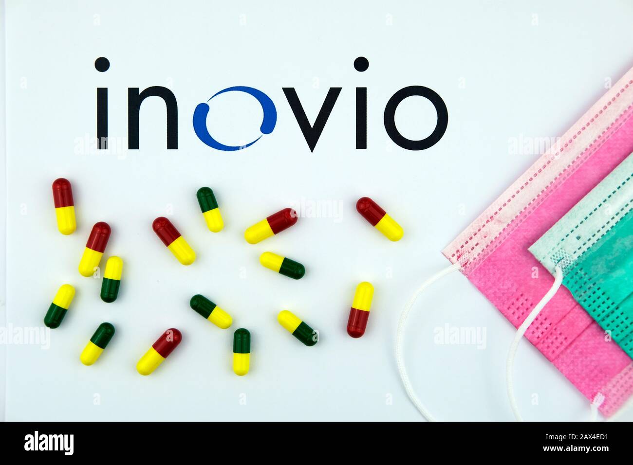 Inovio Pharmaceuticals logo on the brochure, pills and viral masks. Flat lay. Stock Photo