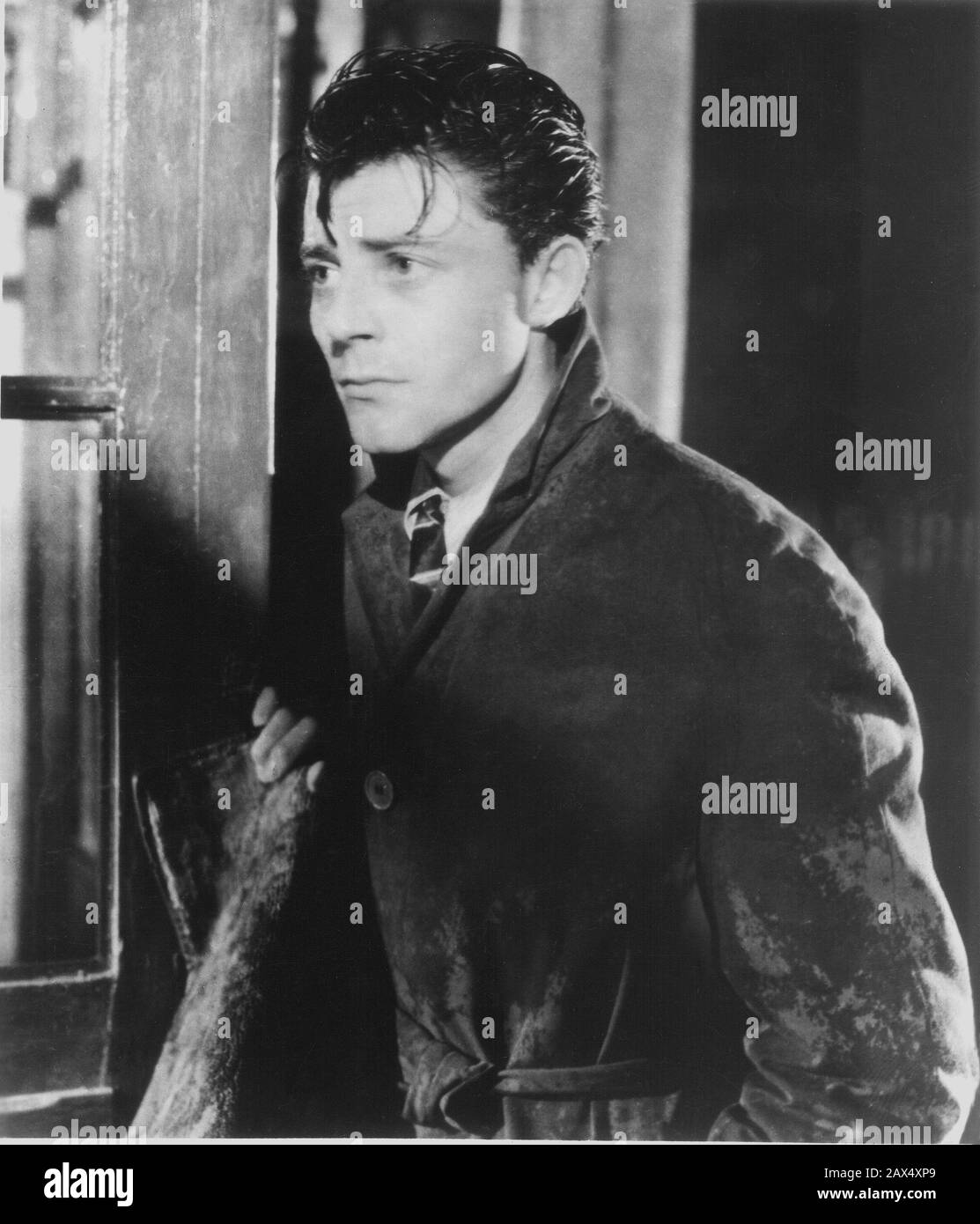 The french movie actor GERARD PHILIPE (   1922 -  1959 )  in LE DIABLE AU CORPS ( Devil in the Flesh -  Il diavolo in corpo ) by Claude Autant-Lara , from a novel by Raymond Radiguet    MOVIE - CINEMA - francese - attore - FILM - impermeabile - raincoat - cravatta - tie - tristezza - gelosia - jealousy - geloso - jealous - sad - grieved - gloomy - distressing - lover - innamorato - amore - love - rain - pioggia  ----  Archivio GBB Stock Photo