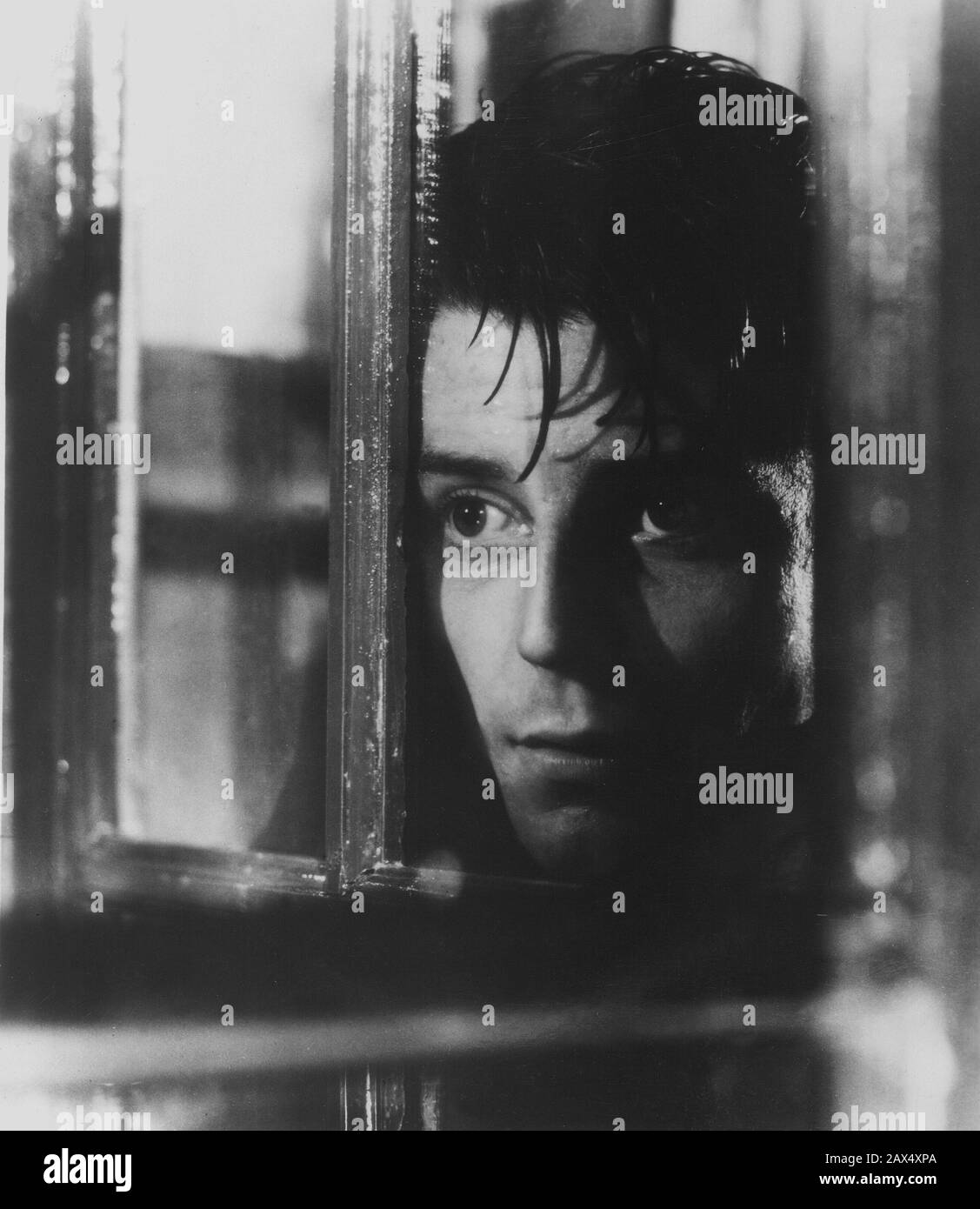 The french movie actor GERARD PHILIPE (  1922 -  1959 )  in LE DIABLE AU CORPS ( Devil in the Flesh -  Il diavolo in corpo ) by Claude Autant-Lara , from a novel by Raymond Radiguet    MOVIE - CINEMA - francese - attore - FILM  - tristezza - gelosia - jealousy - geloso - jealous - sad - grieved - gloomy - distressing - lover - innamorato - amore - love - finestra - window - voyeur - curioso - curious - curiosità - curiosity - spione - rain - pioggia  ----  Archivio GBB Stock Photo