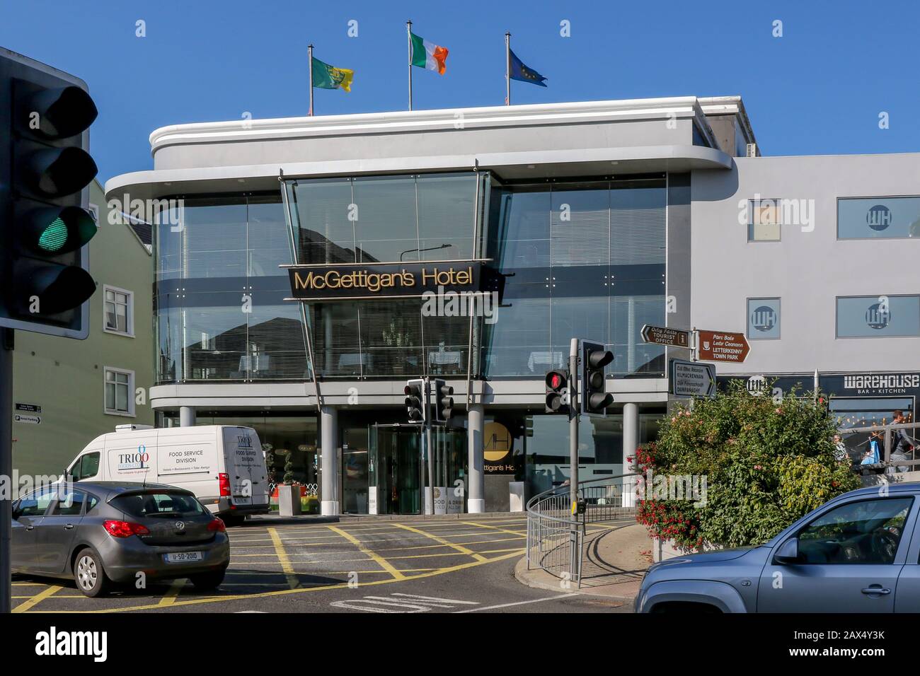 Hotel in town centre Ireland, the modern glass-front McGettigan's Hotel with traffic passing on a bright sunny autumn day in Letterkenny, Ireland. Stock Photo