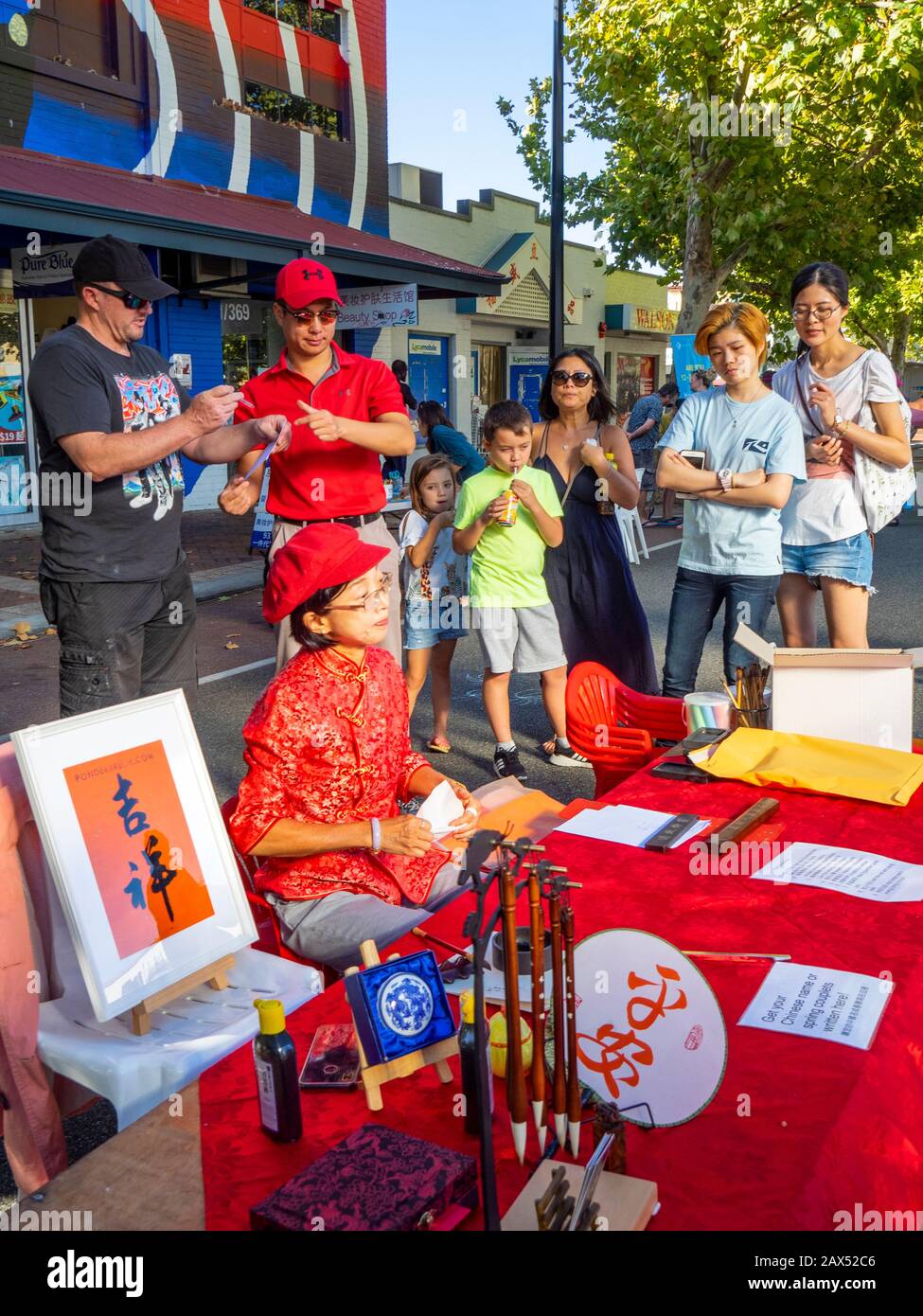 Chinese lady writing in Chinese characters names and spring couplets at Lunar New Year festival 2020 in Northbridge Perth Western Australia. Stock Photo
