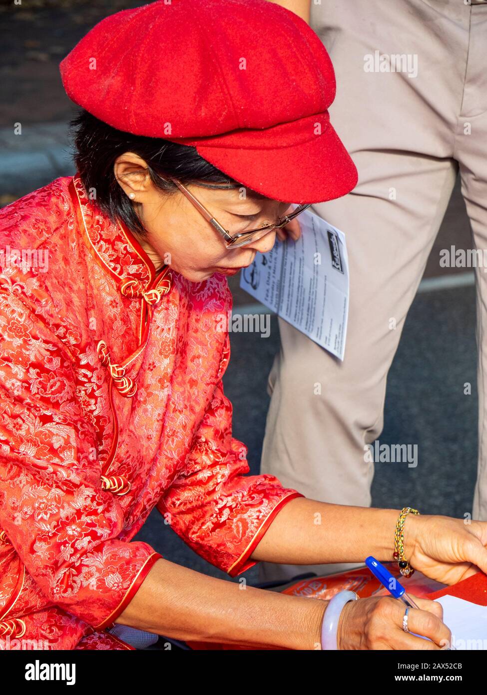 Chinese lady writing in Chinese characters names and spring couplets at Lunar New Year festival 2020 in Northbridge Perth Western Australia. Stock Photo