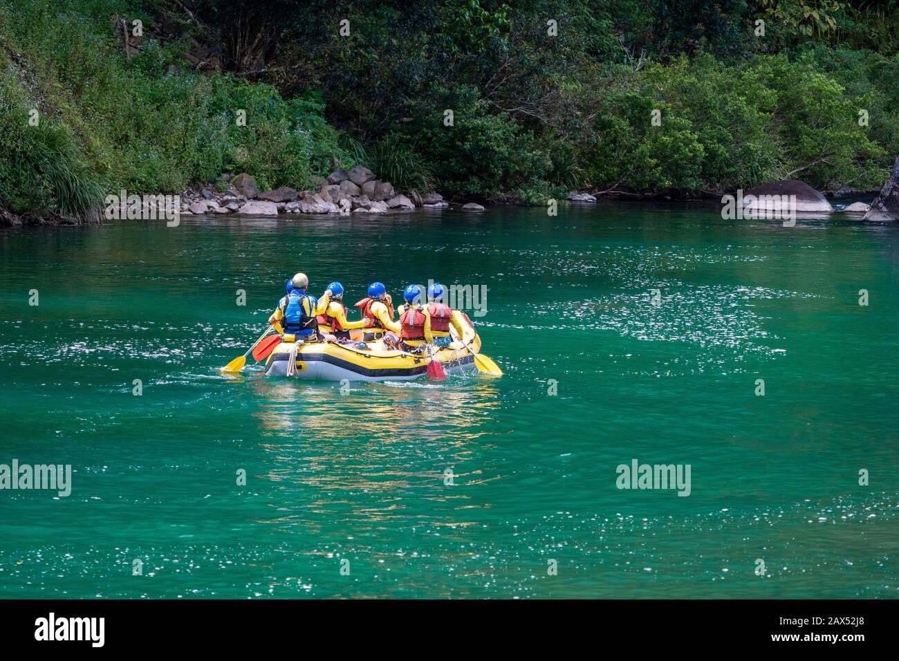 Group of white water rafters paddling through quiet section of Tully Gorge, North Queensland Stock Photo