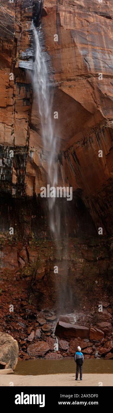 Observing a waterfall that is super tall among red rocks. Stock Photo