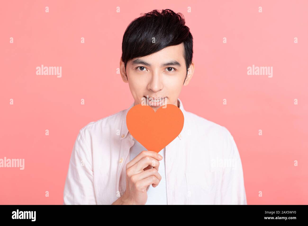 Happy young man  holding red paper hearts  and celebrating  valentines day Stock Photo