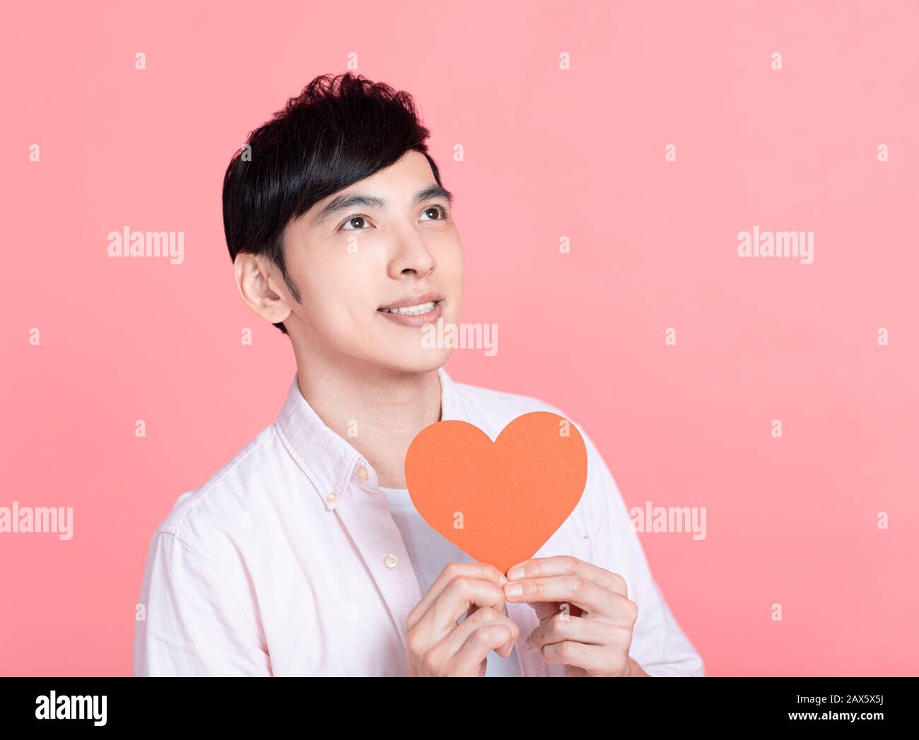 Happy young man  showing red paper hearts  and celebrating  valentines day Stock Photo