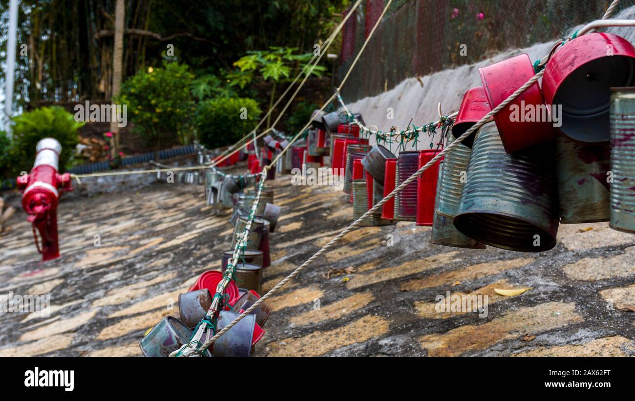 Hong Kong - January 1 2020 : Chain of Tin Cans, Red and Silver Tin Cans hanging on the rope in Tai O Village Stock Photo