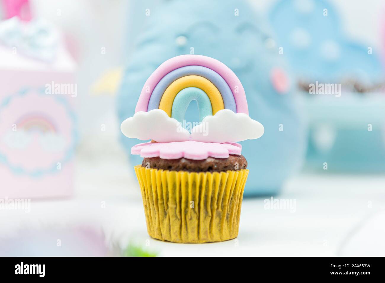 Table of birthday sweets with decorated cupcakes. Cupcake decorated with  umbrella and drops of water, rainbow and cloud with cute face. Selective  focu Stock Photo - Alamy