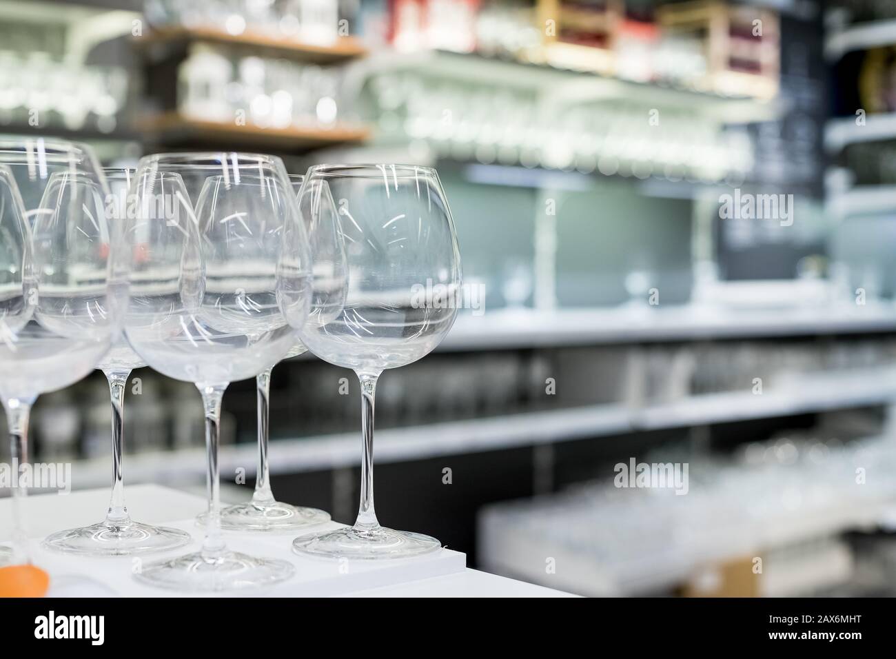 Shelves of modern stemware glasses for sale in store.Glasses and