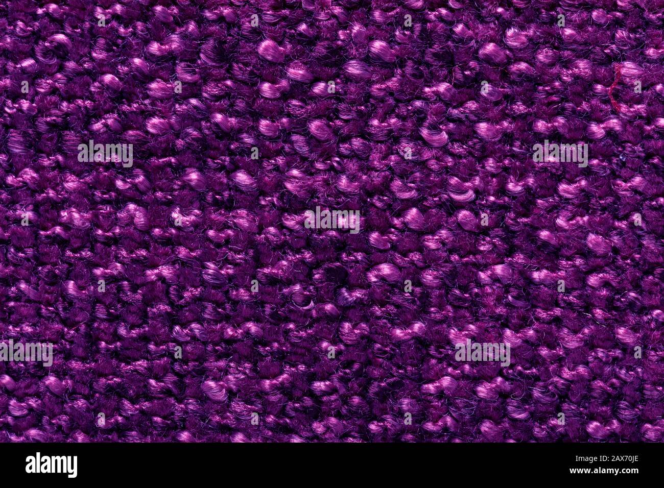 fiber texture polyester close-up. violet fleecy background. shaggy surface. fine grain felt red fabric. Stock Photo