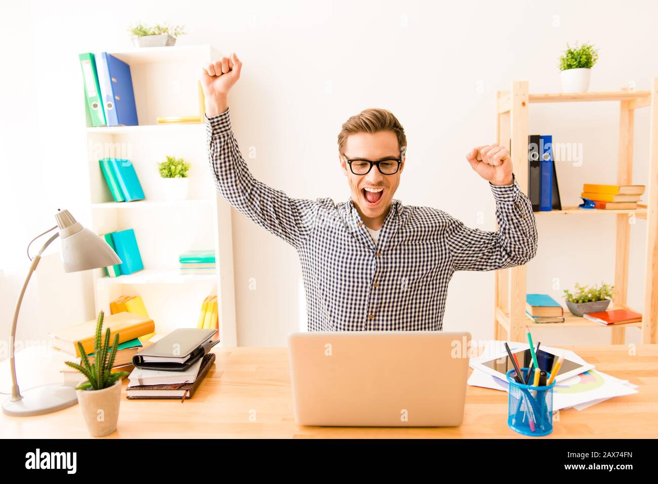 Happy successful young businessman triumphing with raised hands Stock ...