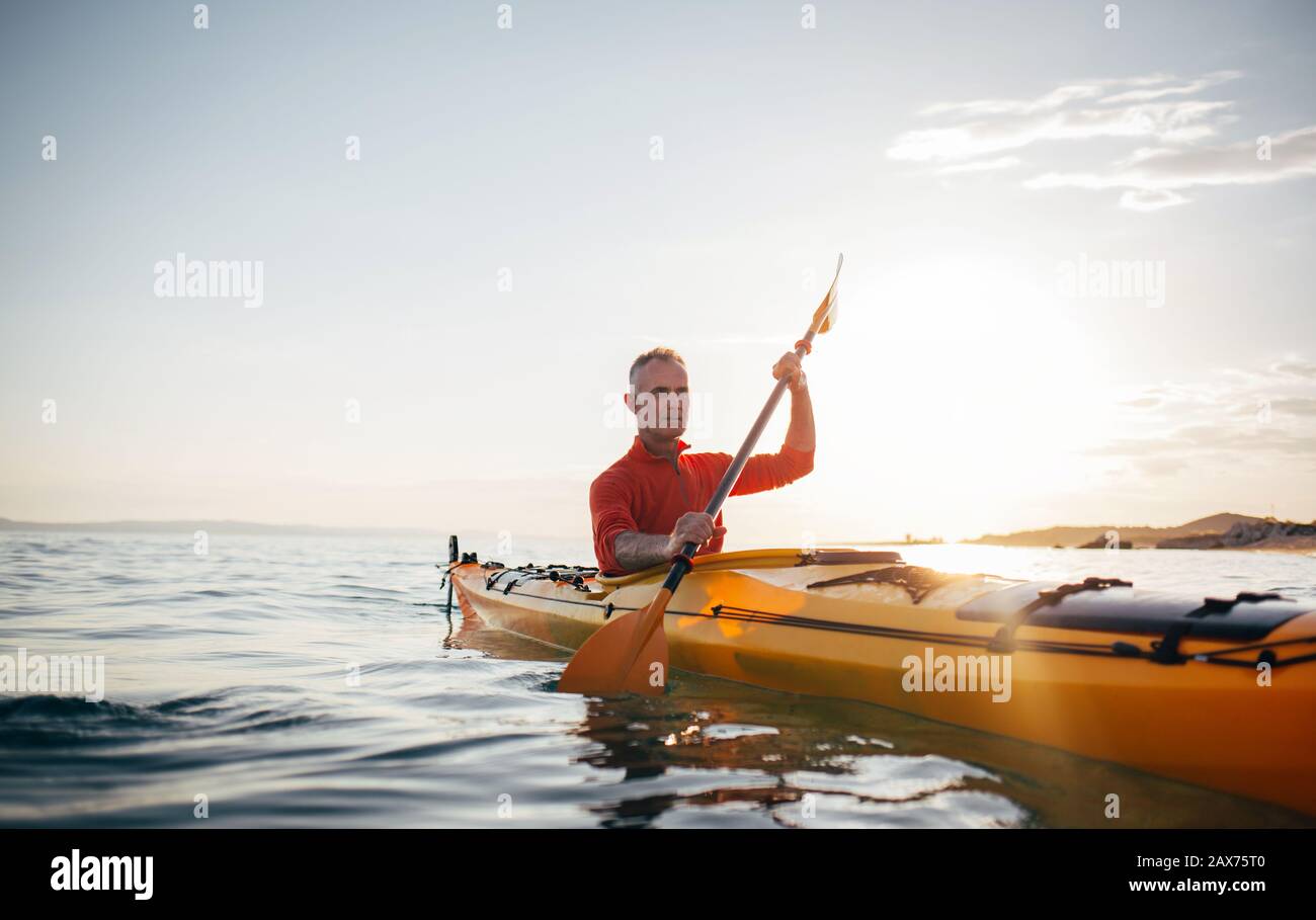 Active senior man paddling kayak. Enjoy sea kayaking Stock Photo