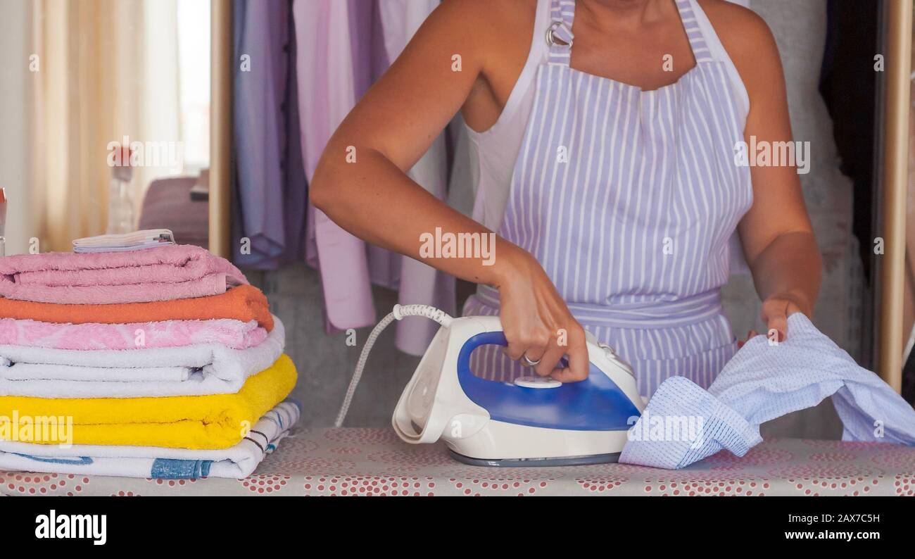 Happy young beautiful woman ironing clothes. Housework Stock Photo - Alamy