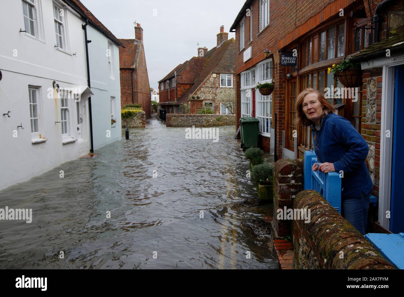 Bosham, West Sussex. 10th Feb 2020. UK Weather: A resident looks out from her home as tides rise in the wake of Storm Ciara and flood the village of Bosham, West Sussex, Uk Monday February 10, 2020.  Many places in the UK remain with yellow weather warnings as the Storm Ciara weather front continues.  Photograph : Luke MacGregor Credit: Luke MacGregor/Alamy Live News Stock Photo