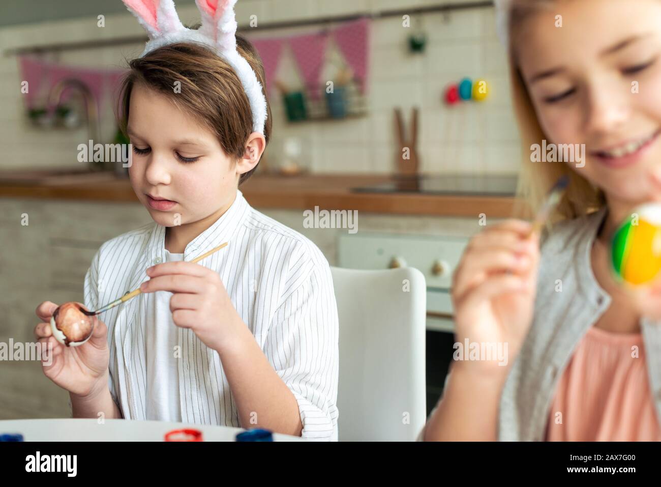 Happy kids coloring Easter eggs, preparing Easter basket Stock Photo