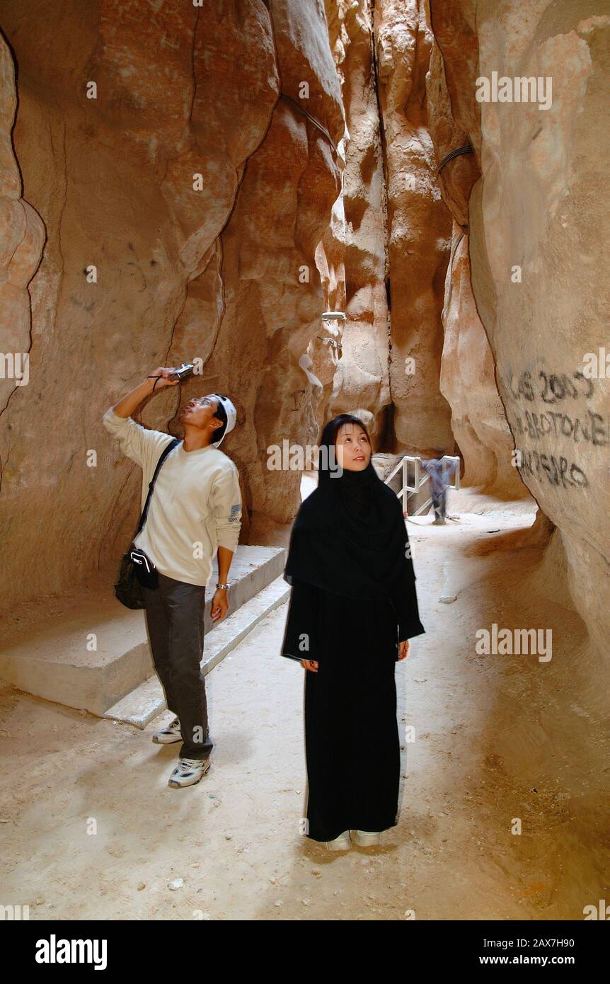 Japanese couple inside a cave in Jabal Gara mountain in al Hassa, Saudi Arabia. Stock Photo