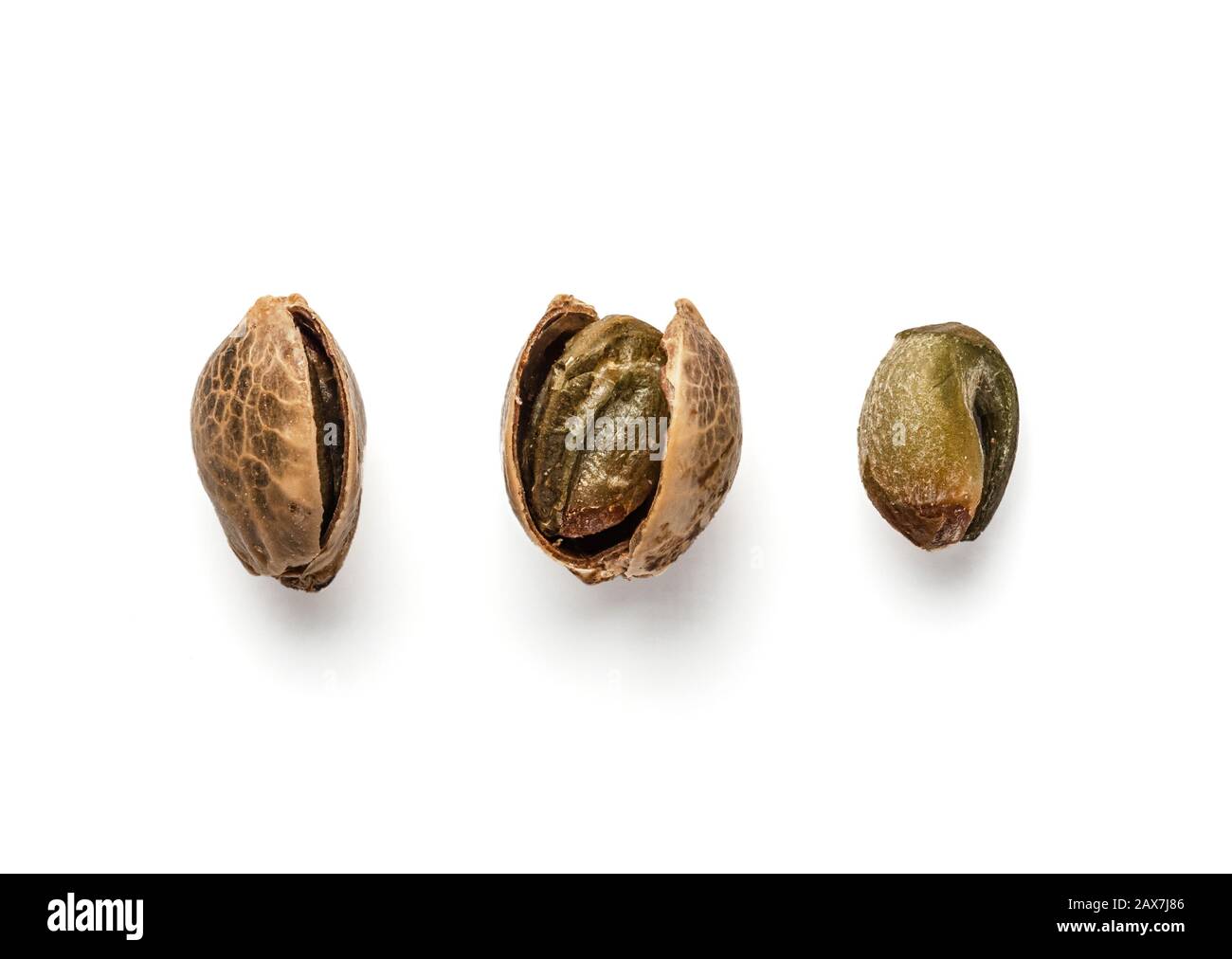 Creative layout of hemp seeds. Superfood hemp concept. Top view of three cannabis or hemp seeds in shell, open shell and unshelled seed kernel. Isolated on white with clipping path. Stock Photo