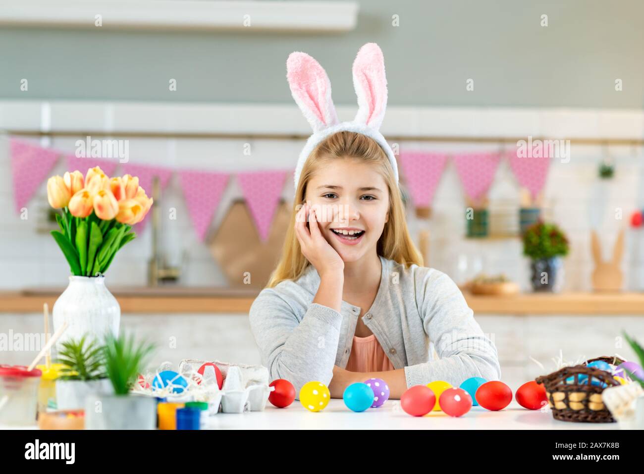 Portrait of happy little girl sitting at the table and happily smiling ...