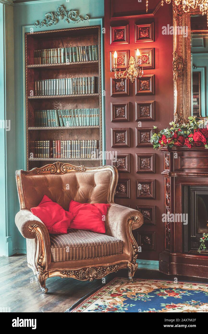 Luxury classic interior of home library. Sitting room with bookshelf,  books, arm chair, sofa and fireplace. Clean and modern decoration with  elegant furniture. Education read study wisdom concept Stock Photo - Alamy