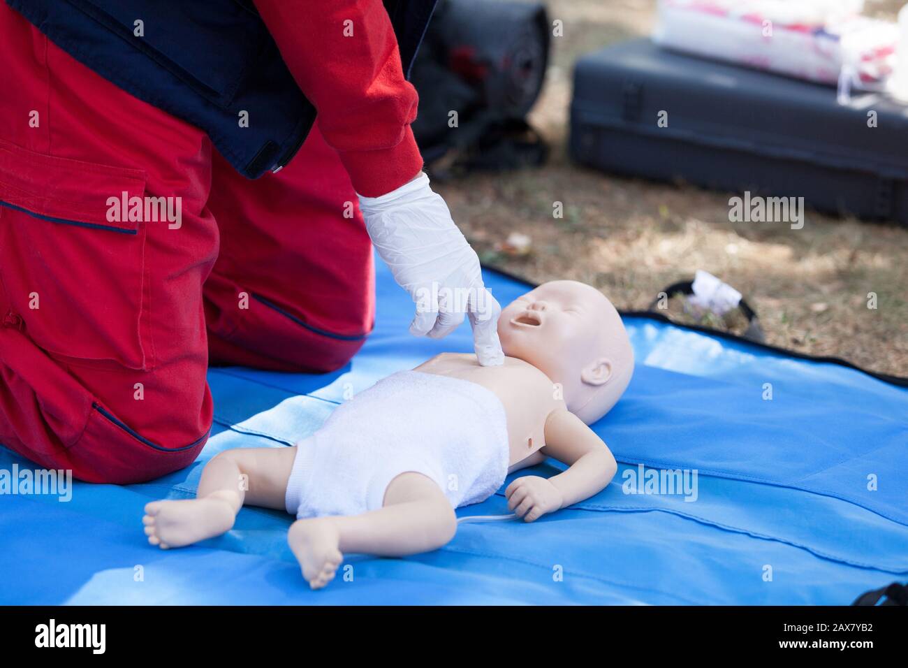 Paramedic performing CPR on baby dummy with two-finger chest compression Stock Photo