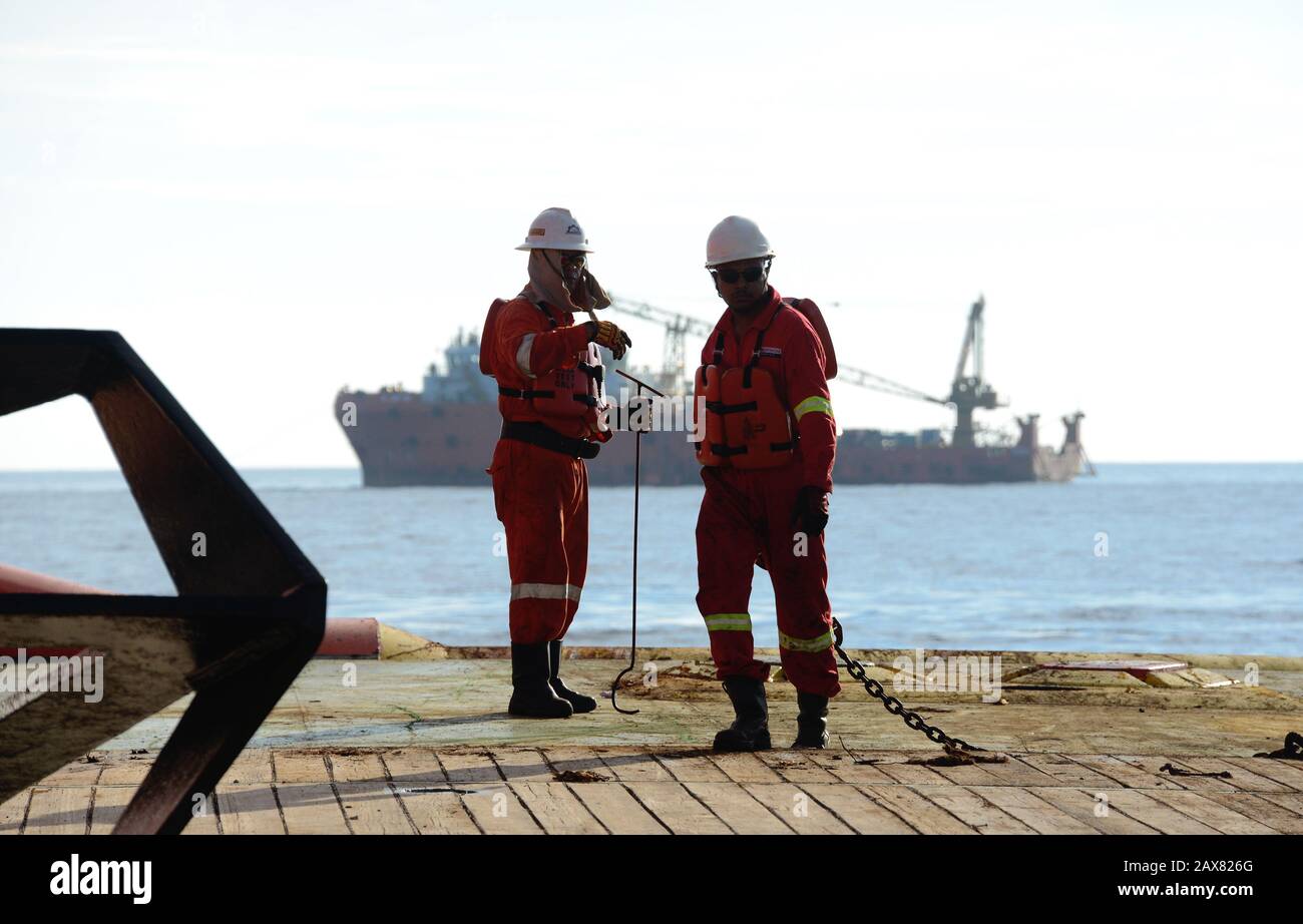 marine crew commencing work on deck for anchor handling operation Stock