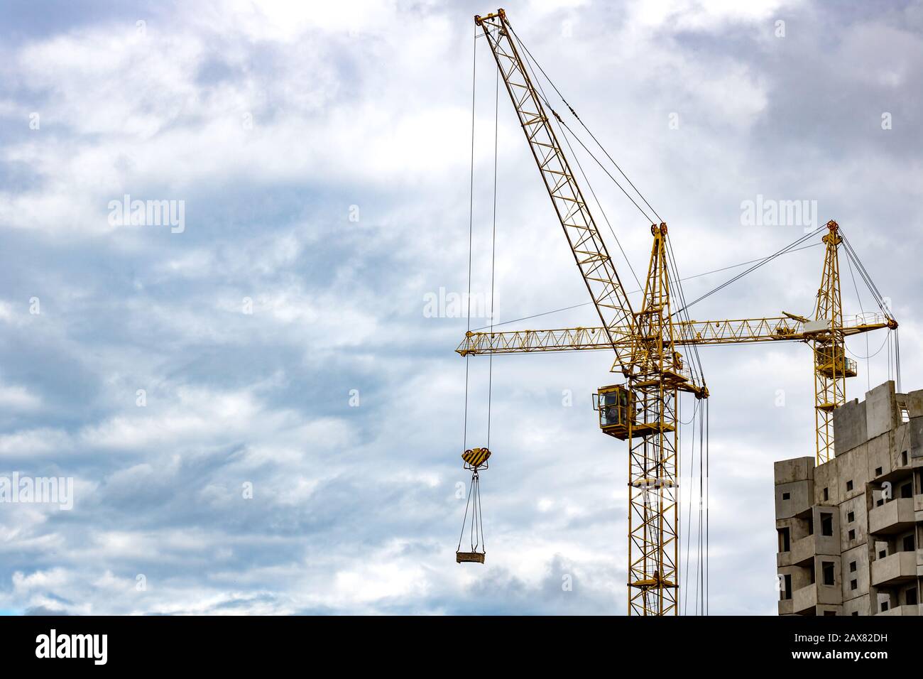 Construction crane against a cloudy sky background Stock Photo - Alamy