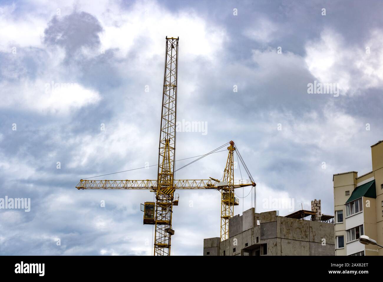 Construction crane against a cloudy sky background Stock Photo - Alamy