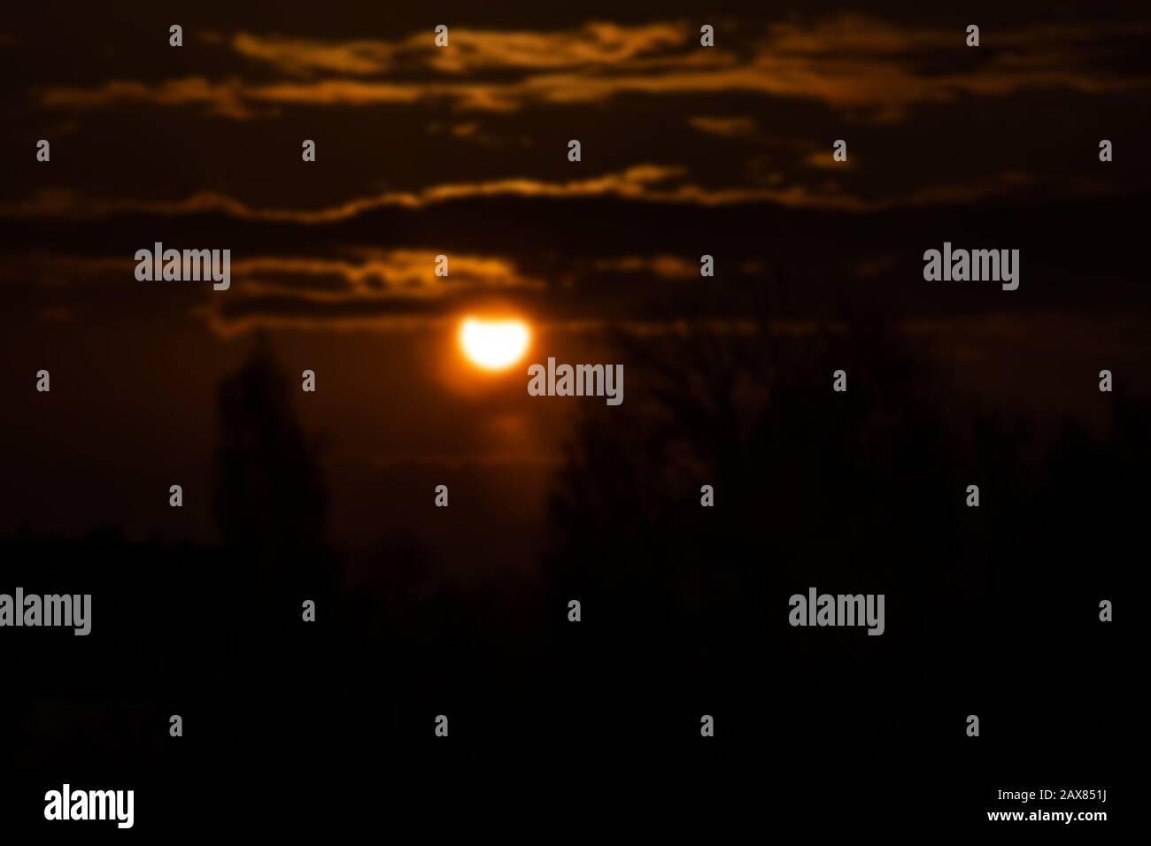 Sun in the red sky at sunrise, blurred background Stock Photo - Alamy