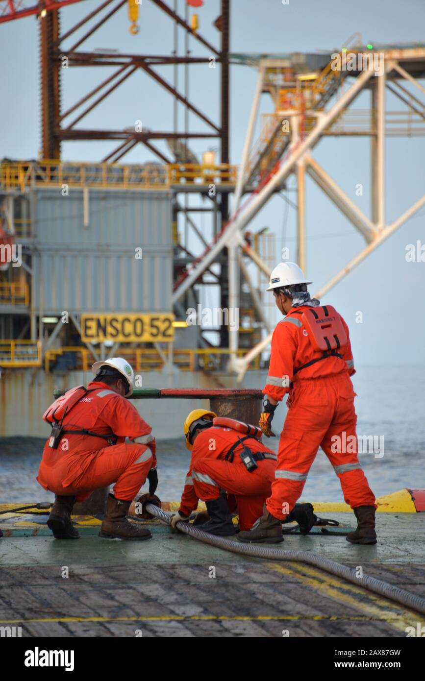 Marine crew commencing  anchor handling operation on deck for jack up rig Stock Photo