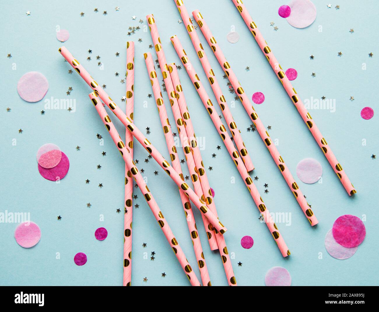 Drinking straws for party and confetti on blue background with copy space. Top view of colorful paper disposable eco-friendly straws for summer cockta Stock Photo