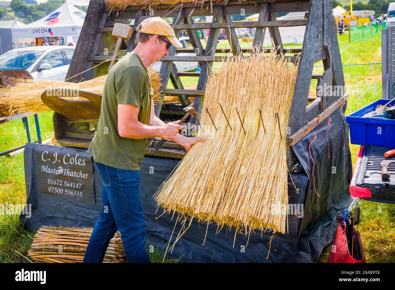 A master thatcher demonstrating his thatching techniques at the Heddington Steam Fair and Country Show in Wiltshire England UK Stock Photo