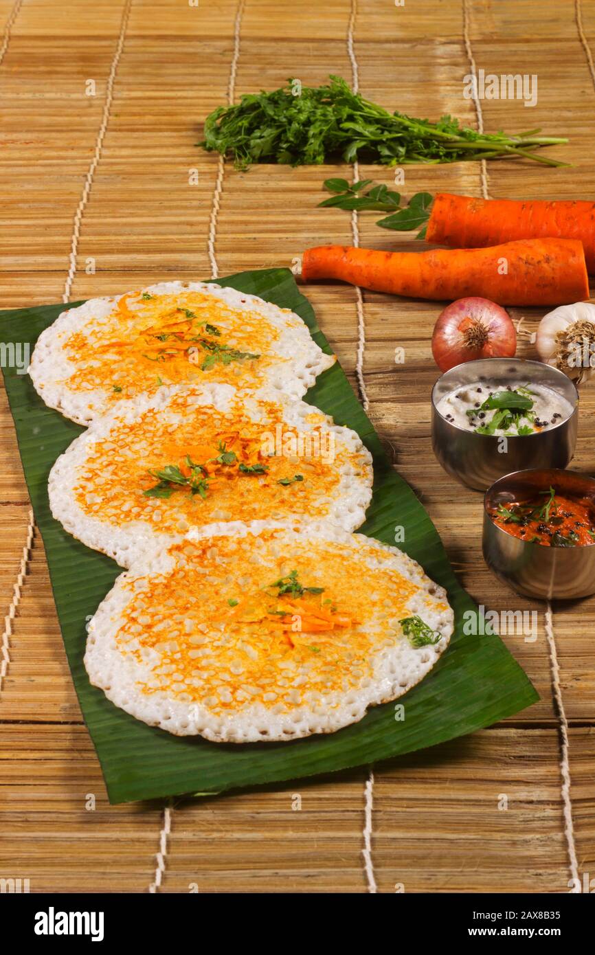 Thick spongy dosas served together with coconut chutney and sambhar on