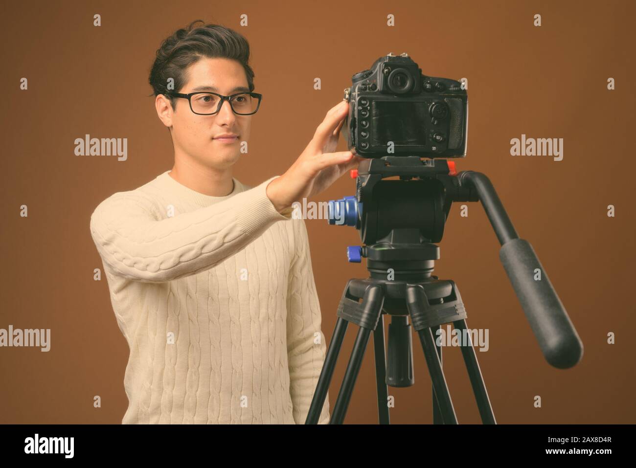 Young multi ethnic handsome man against brown background Stock Photo