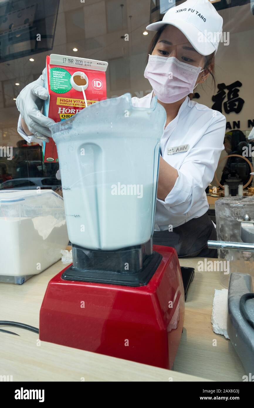 A young Asian American prepares boba drinks in the window at Xing Fu Tang, a Taiwanese store on Main St. in Flushing, Queens, New York's Chinatown. Stock Photo