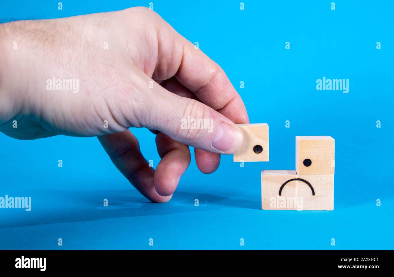 A very sad looking face on wooden blocks, the face showing sadness and