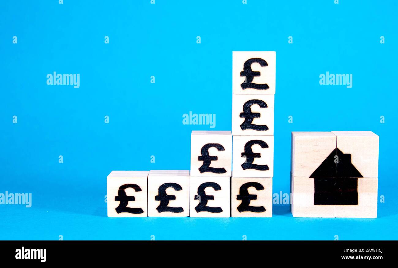 The cost of housing is a huge issue nationally and internationally. Here wooden blocks with symbols of currency show the rising costs of property inve Stock Photo