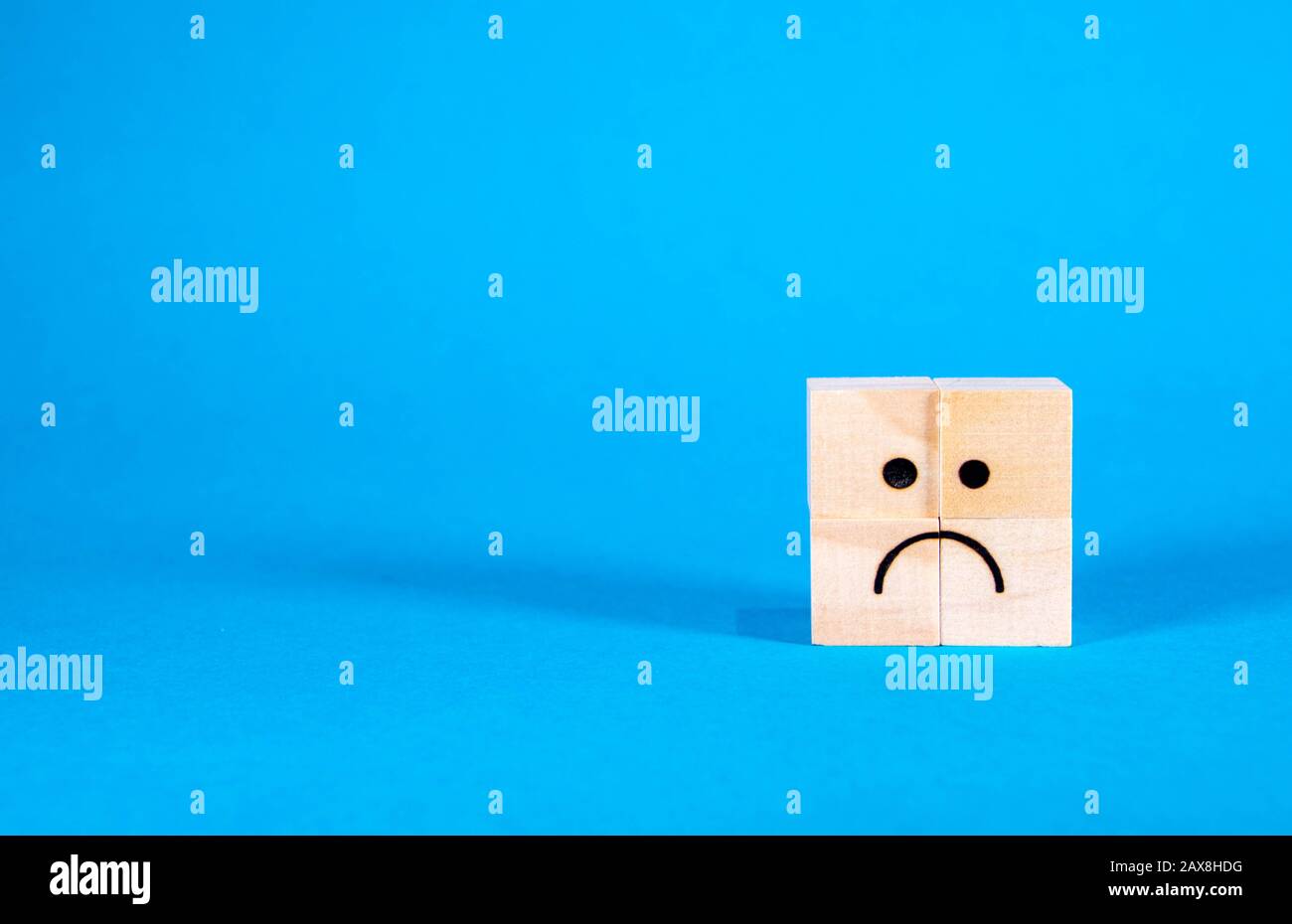 A very sad looking face on wooden blocks, the face showing sadness and