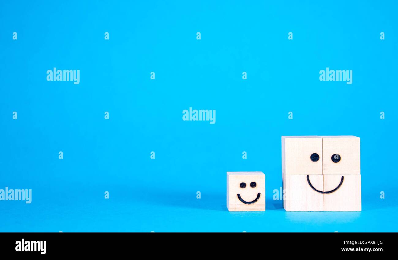 Two wooden blocks with happy faces, smile as they stand side by side. Stock Photo