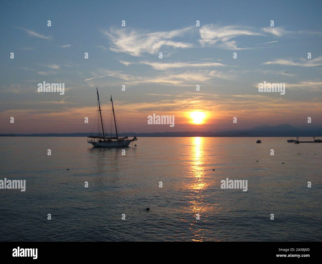 Sailboat at sunset in lake Garda in Italy, Lago di Garda Stock Photo