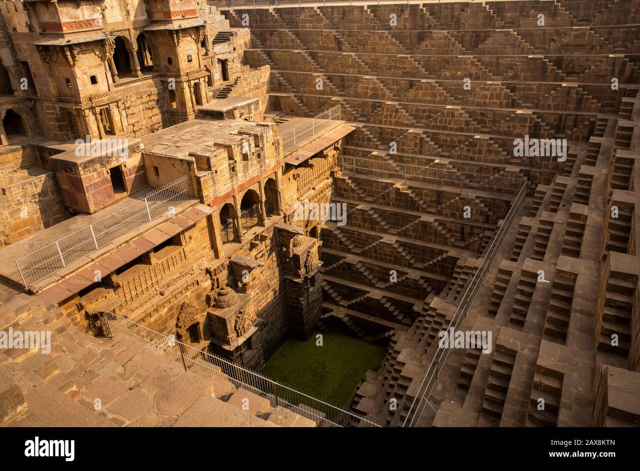 India, Rajasthan, Abhaneri, Chand Baori Stepwell, named after a local ruler called Raja Chanda, Upper Palace building and tiered steps down to water Stock Photo