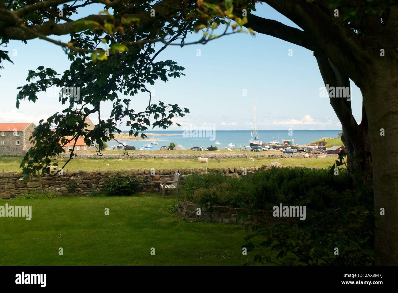 View of a quiet bay and small english town with green grass meadow and view of the sea Stock Photo
