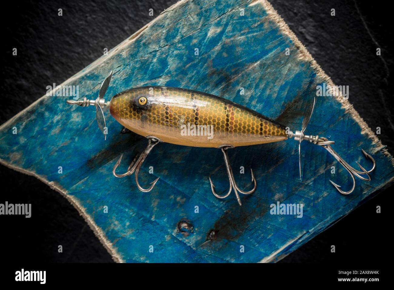 https://c8.alamy.com/comp/2AX8W4K/an-old-south-bend-fishing-lure-or-plug-designed-to-catch-predatory-fish-photographed-on-a-piece-of-driftwood-the-lure-came-from-a-collection-of-vi-2AX8W4K.jpg