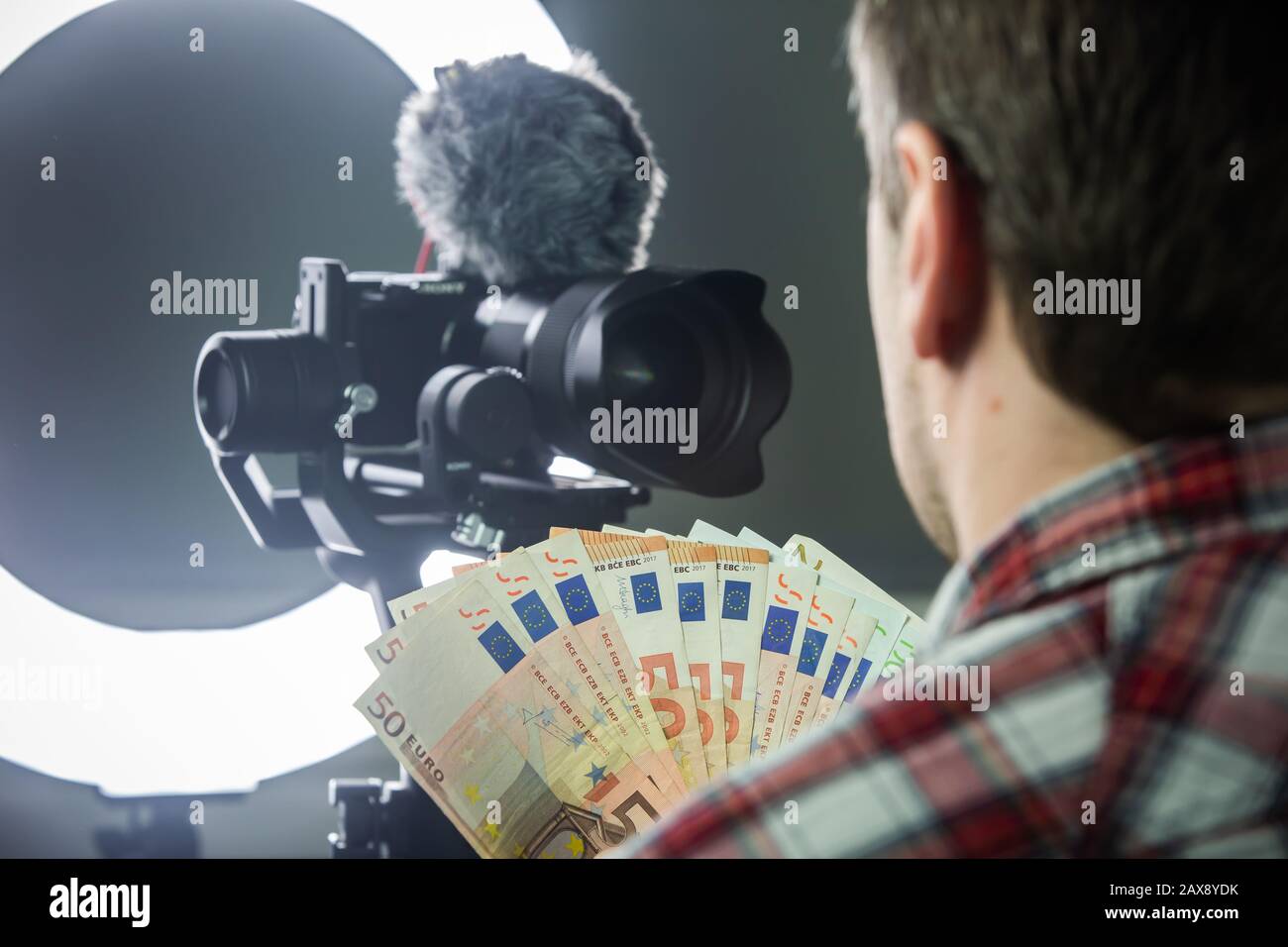 Male vlogger counting money from vlogging Stock Photo