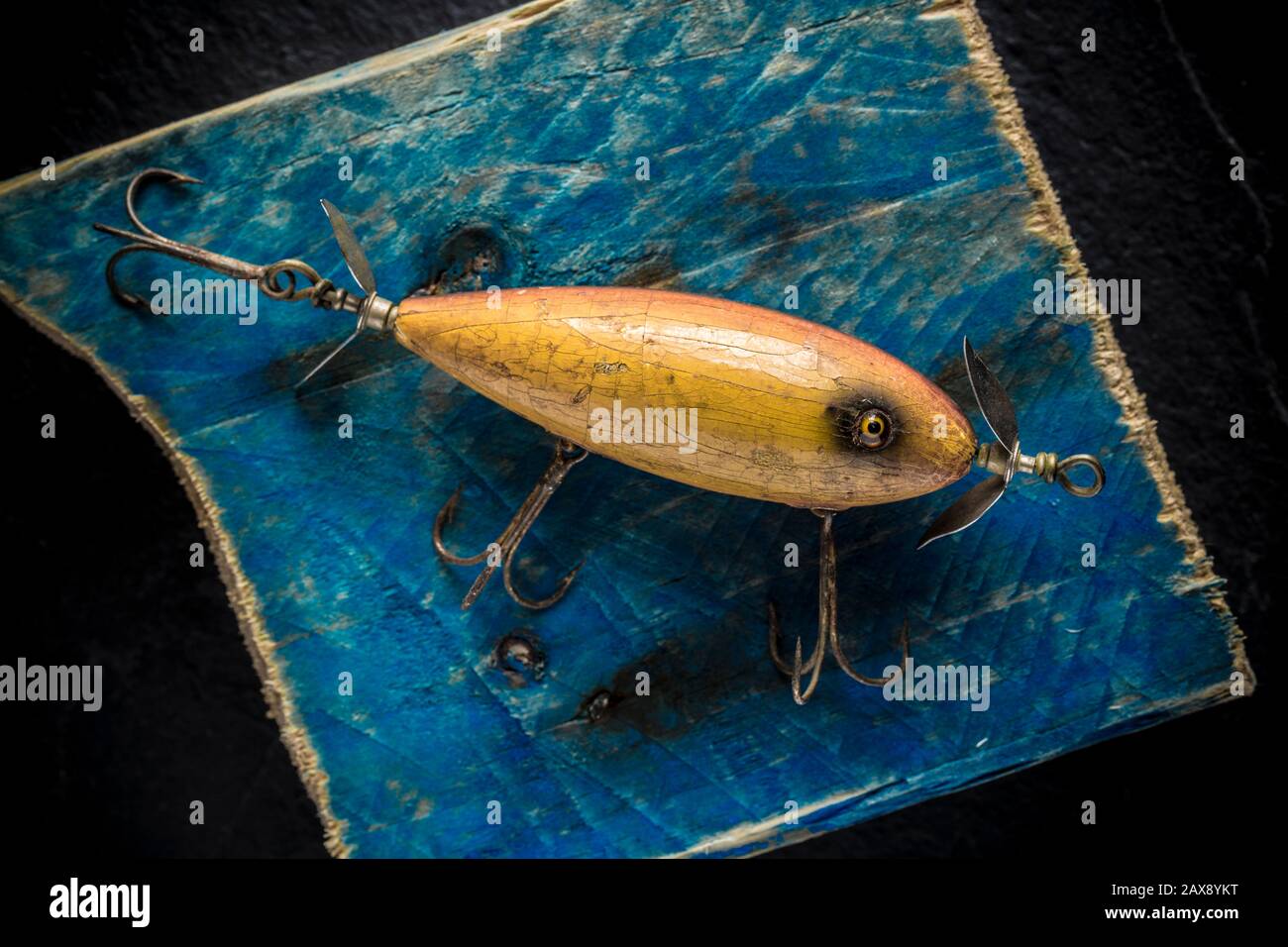 An old South Bend fishing lure, or plug, designed to catch predatory fish, photographed on a piece of driftwood. The lure came from a collection of vi Stock Photo