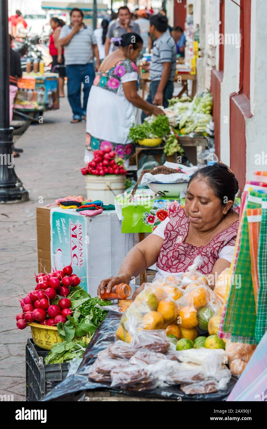 Woman selling vegetables and fruits, wearing huipil, traditional Mayan dress, at Calle 44 in Valladolid, Yucatan state, Mexico Stock Photo