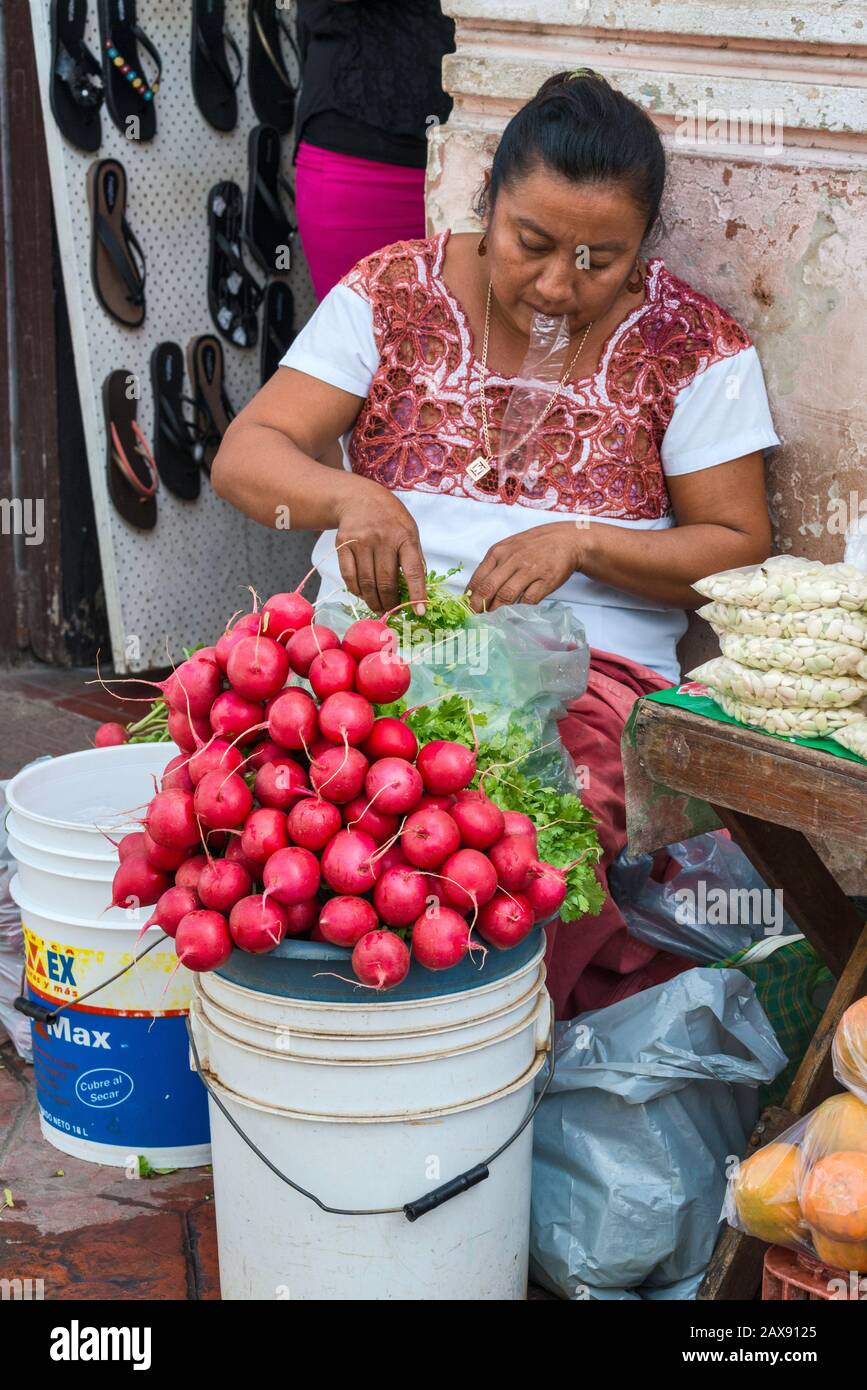 Woman selling vegetables and fruits, wearing huipil, traditional hand-embroided Mayan dress, at Calle 44 in Valladolid, Yucatan state, Mexico Stock Photo