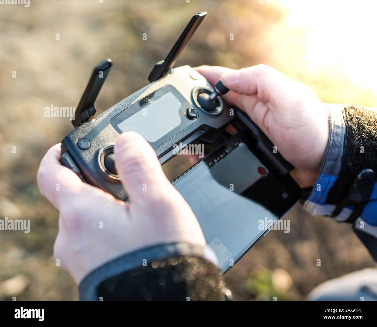 Man operating drone / man holding remote control drones / drone controller. Stock Photo