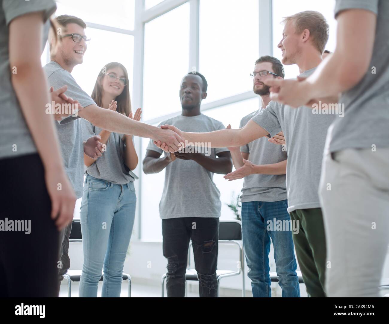 young people shaking hands, standing in a circle of friends Stock Photo ...