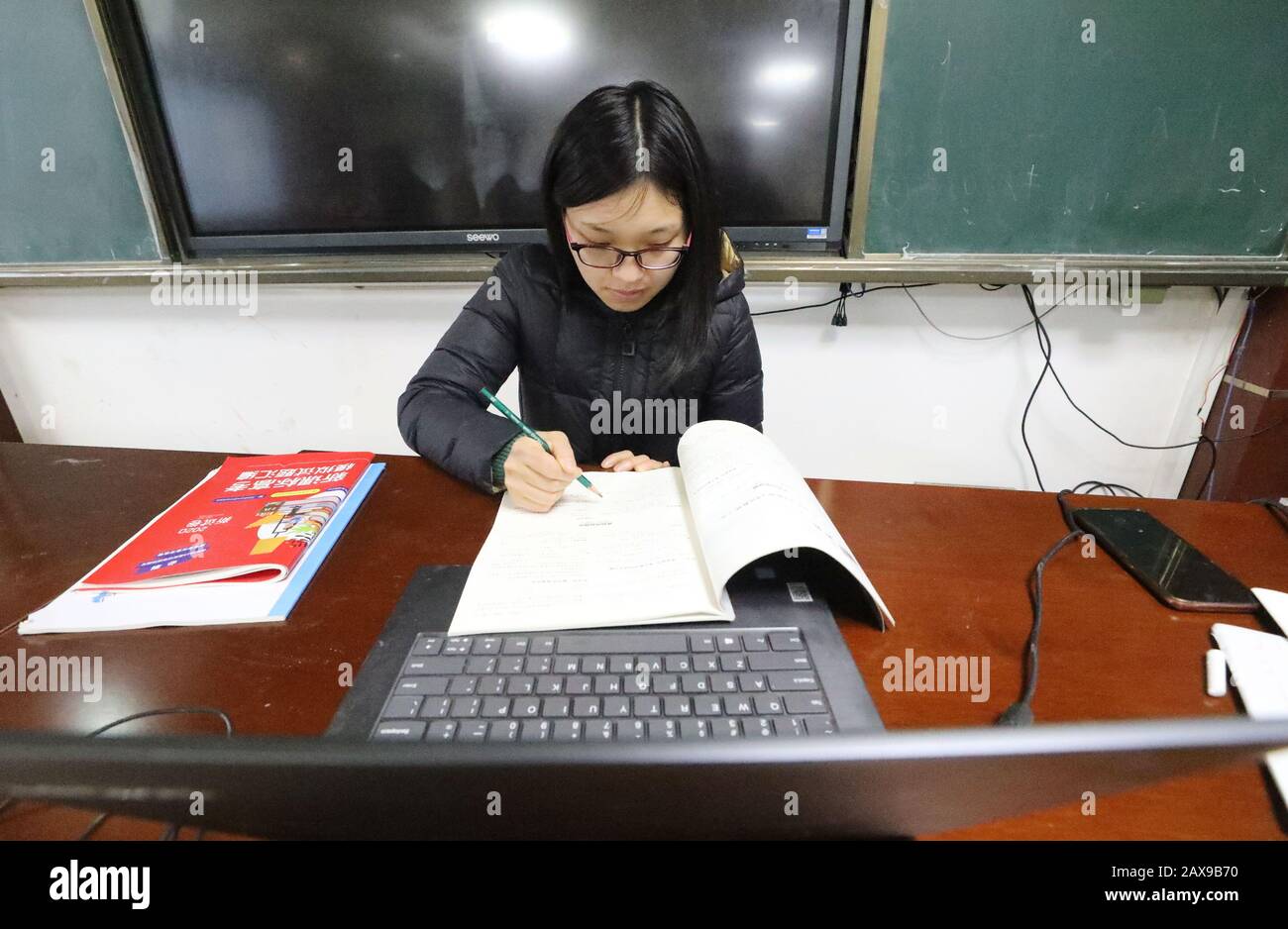 A Chinese teacher gives a lessen to her students through the Internet ...